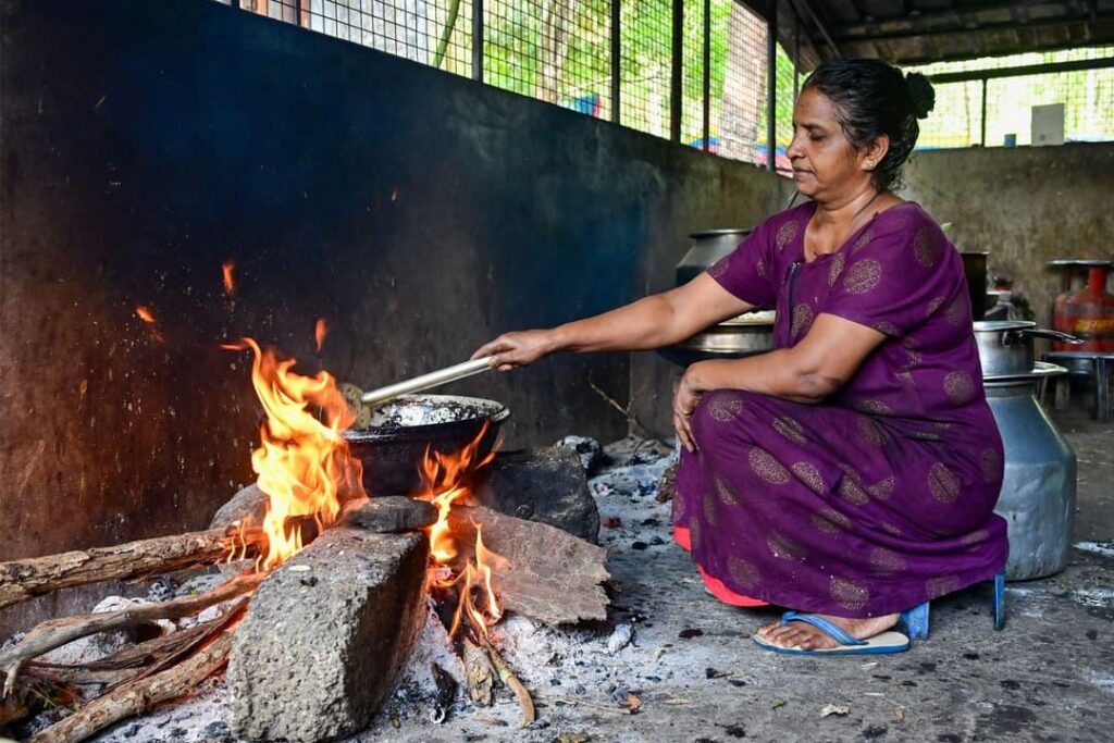 Woman cooking traditional food over a wood fire.